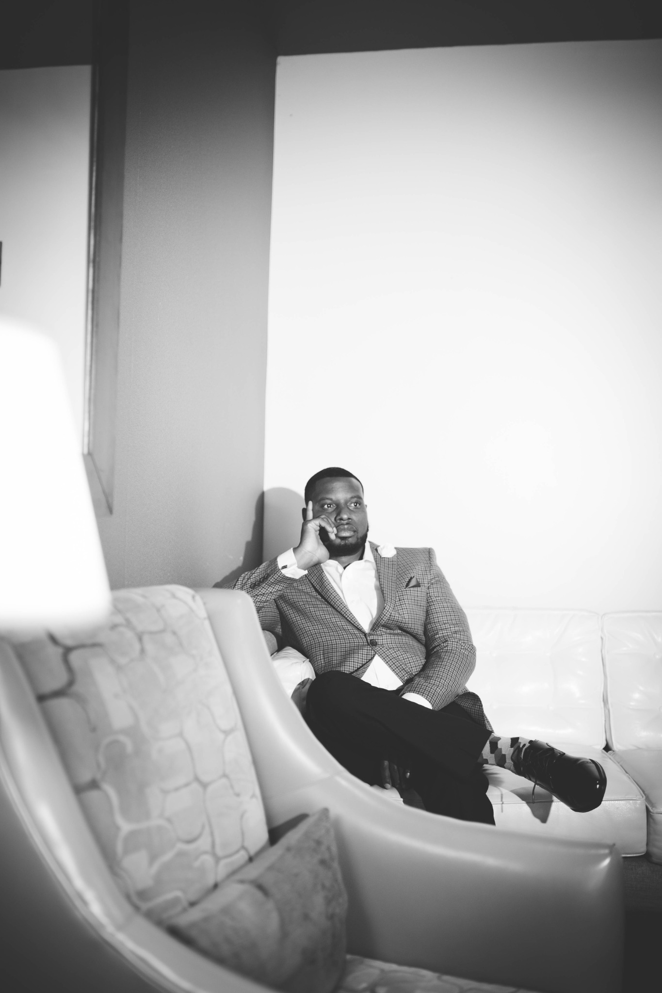 Black-and-white portrait of Antoine Sherman seated on a sofa